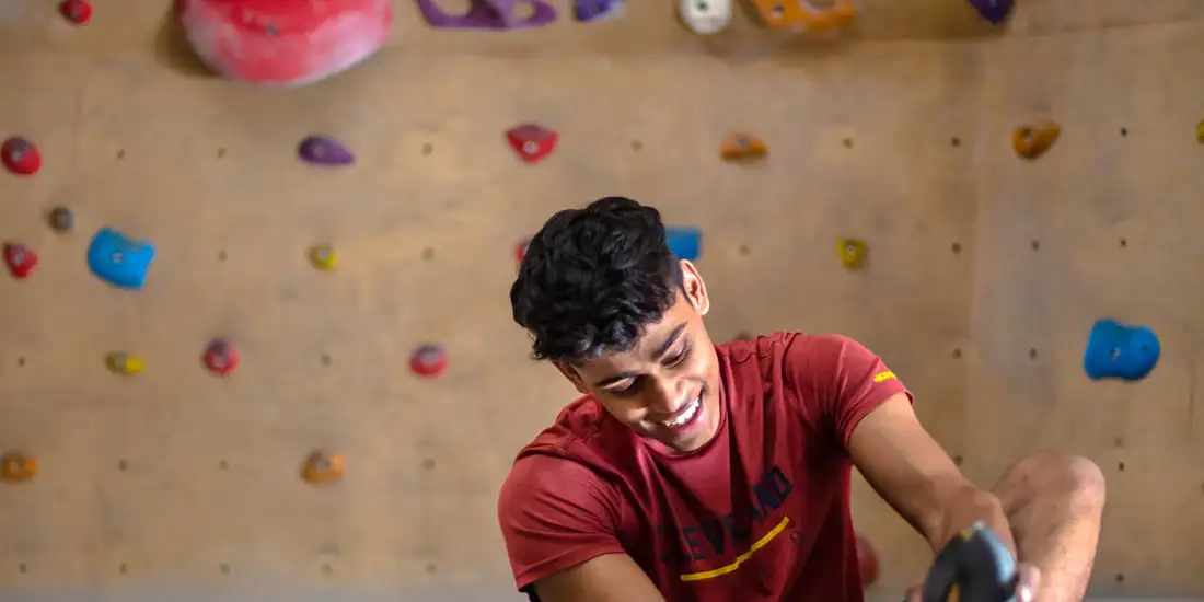 A climber putting on climbing shoes at BoulderBox